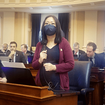 A photo of Kathy Tran with a microphone. 